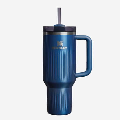 A blue Stanley vacuum-insulated tumbler with a handle, lid, and straw, shown against a light gray background.