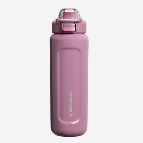 A pink Stanley water bottle with a matching pink lid and a clear protective cap, shown against a plain light gray background.